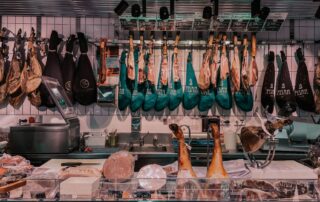 Vista interior de una carnicería profesional limpia y organizada con maquinaria industrial visible.